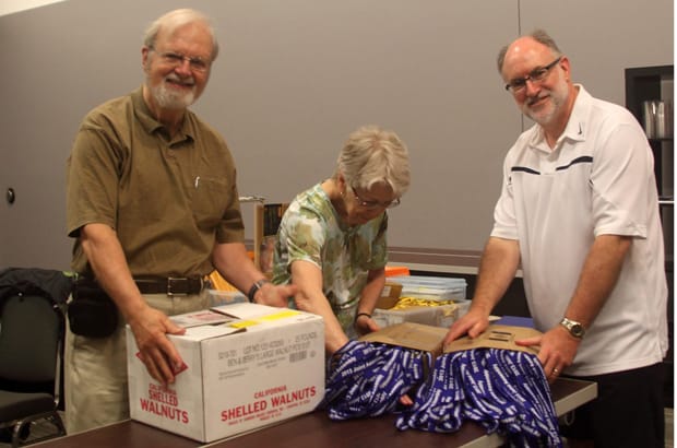 Ottawa volunteer Bob Green, (left) Dianne Izzard, Anglican Church of Canada co-ordinator for General Synod, and Jamie Tomlinson, Anglican chair of the local arrangements committee, help unpack delegates lanyards and other supplies at the Ottawa Convention Centre. Photo: Art Babych