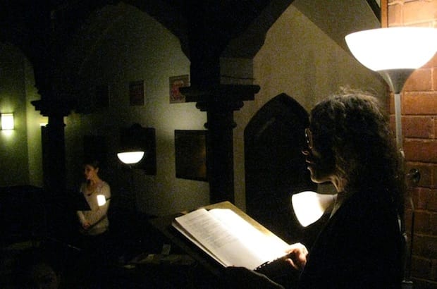 The Rev. Maggie Helwig reads from Dennis Lee's poetry collection Testament while Kristin Ostensen sings as a part of a Nuit Blanche performance art installation at Toronto's St. Stephen-in-the-Fields on Oct. 4. Photo: André Forget