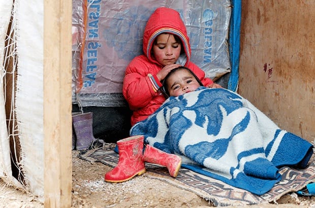 A Syrian refugee girl sits with her brother at a makeshift shelter in Bar Elias, a town in Lebanon's Bekaa Valley. Photo: Mohamed Azakir/Reuters