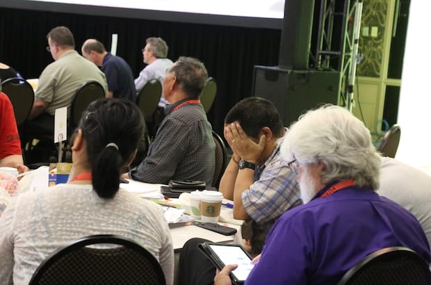 Some members take a breather as the officers of General Synod confer about what to do with the discovery of voting error. Photo: Art Babych