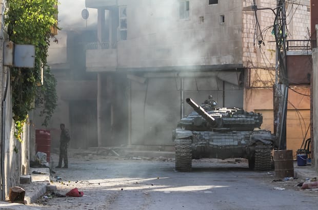 A Syrian Army tank stands between buildings during an operation September 2013 in the suburbs of Damascus. Photo: ART production/Shutterstock
