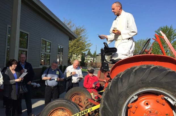The Rev. Jim Eichner, rector of the Episcopal Church of the Holy Cross in Redmond, Washington, blesses a Food Bank Farm vehicle. Photo: Episcopal Church of the Holy Cross