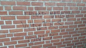 Vandals wrote "Trump Nation Whites Only" on the red-brick wall in Church of Our Saviour's memorial garden. Photo: Facebook