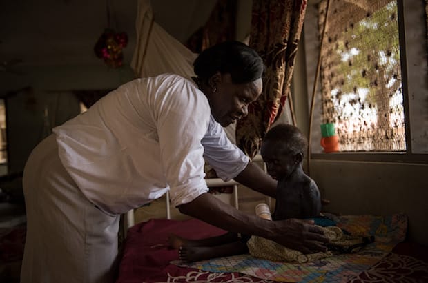 Health worker Betty Achan examines two-year-old Njuma Simon, who suffers from malnutrition, at the Al Sabbah Children’s Hospital in Juba, South Sudan. Photo: © UNICEF/UN057888/Hatcher-Moore