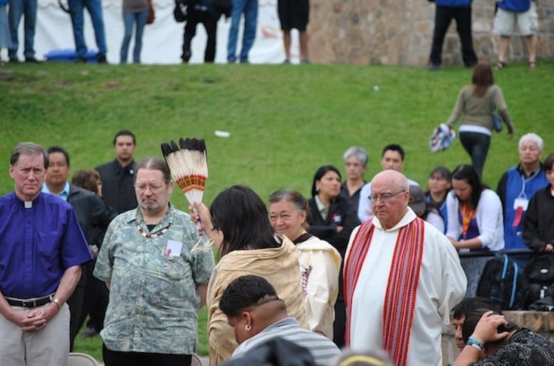 Archbishop Fred Hiltz, primate of the Anglican Church of Canada, and National Indigenous Anglican Bishop Mark MacDonald are blessed by an elder at the first TRC national event in Winnipeg in 2010. Photo: Marites N. Sison