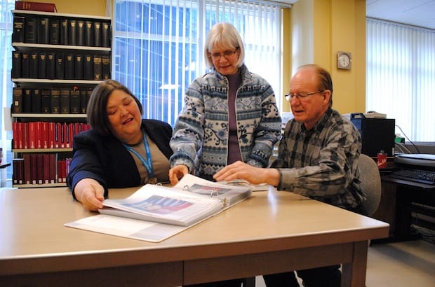 (L-R) General Synod archivist Nancy Hurn, assistant archivist Laurel Parson and former general secretary Archdeacon Jim Boyles look at some of the photos from the General Synod archives relating to Indian residential schools. Photo: André Forget