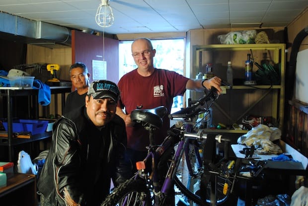 Mike Hahn (R) helps a parishioner fix a rental bicycle in the basement of St. Alban's, Beamsville. Photo: André Forget