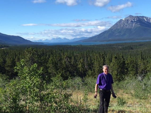 Archbishop Fred Hiltz poses in front of an impressive mountain peak in Atlin, B.C. Photo: Diocese of Yukon 