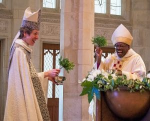Presiding Bishop Michael B.Curry and 26th Presiding Bishop Katharine Jefferts Schori exchange a playful laugh as they prepare to asperge the congregation assembled in Washington National Cathedral for Curry's installation service. Photo: Danielle Thomas (c) 2015 Washington National Cathedral
