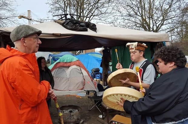 Victoria's tent city residents greet Bishop Logan McMenamie with drumming during his visit March 26. Photo: Super InTent City Facebook page
