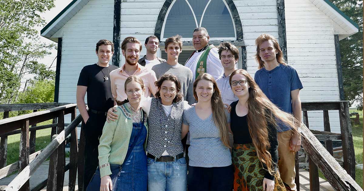 Sanderson, rear centre, poses with a ministry team from King’s College, Halifax, on the steps of St. Stephen’s Church in James Smith First Nation. Photo: Karis Tees