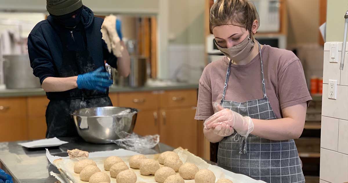 Bakers at Trinity Youth Project prepare buns for two diocese of Edmonton parishes running food security programs during the COVID-19 pandemic. Photo: Clark Hardy