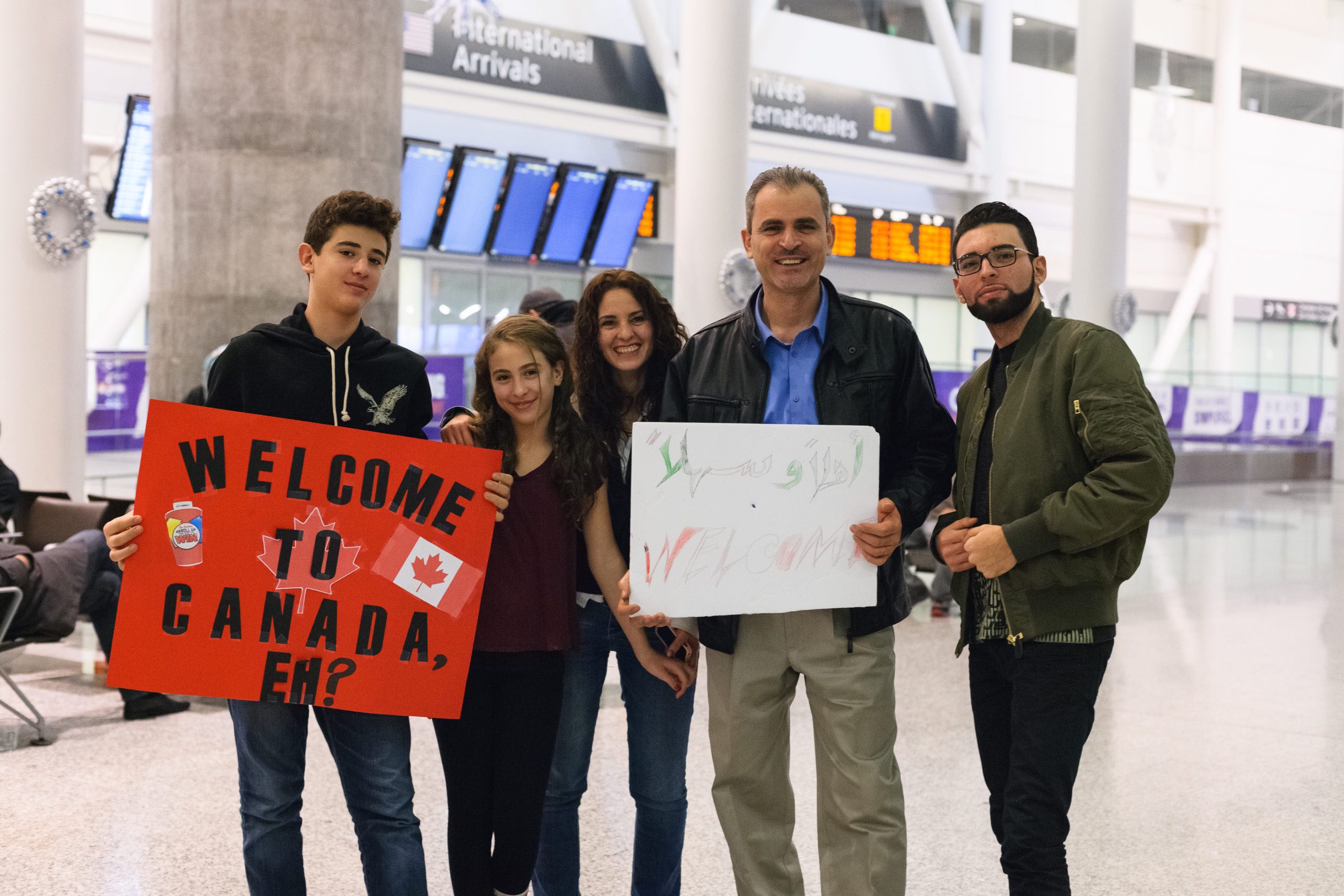 The Rafeeh family, originally from Syria, waits to welcome Syrian refugees at Toronto’s Pearson airport in 2015. Photo: Stacey Newman/Shutterstock
